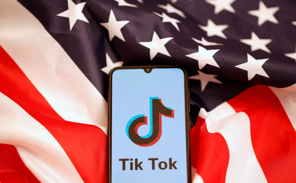The TikTok logo is displayed on the smartphone while standing on the U.S. flag in this illustration picture taken on Nov. 8, 2019. (Dado Ruvic/Reuters)