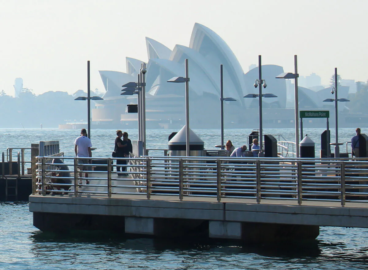Commuters wait for a ferry as smoke from bushfires shrouds the Sydney Opera House in Sydney, Australia, on Nov. 12, 2019. (Jonathan Barrett/Reuters)