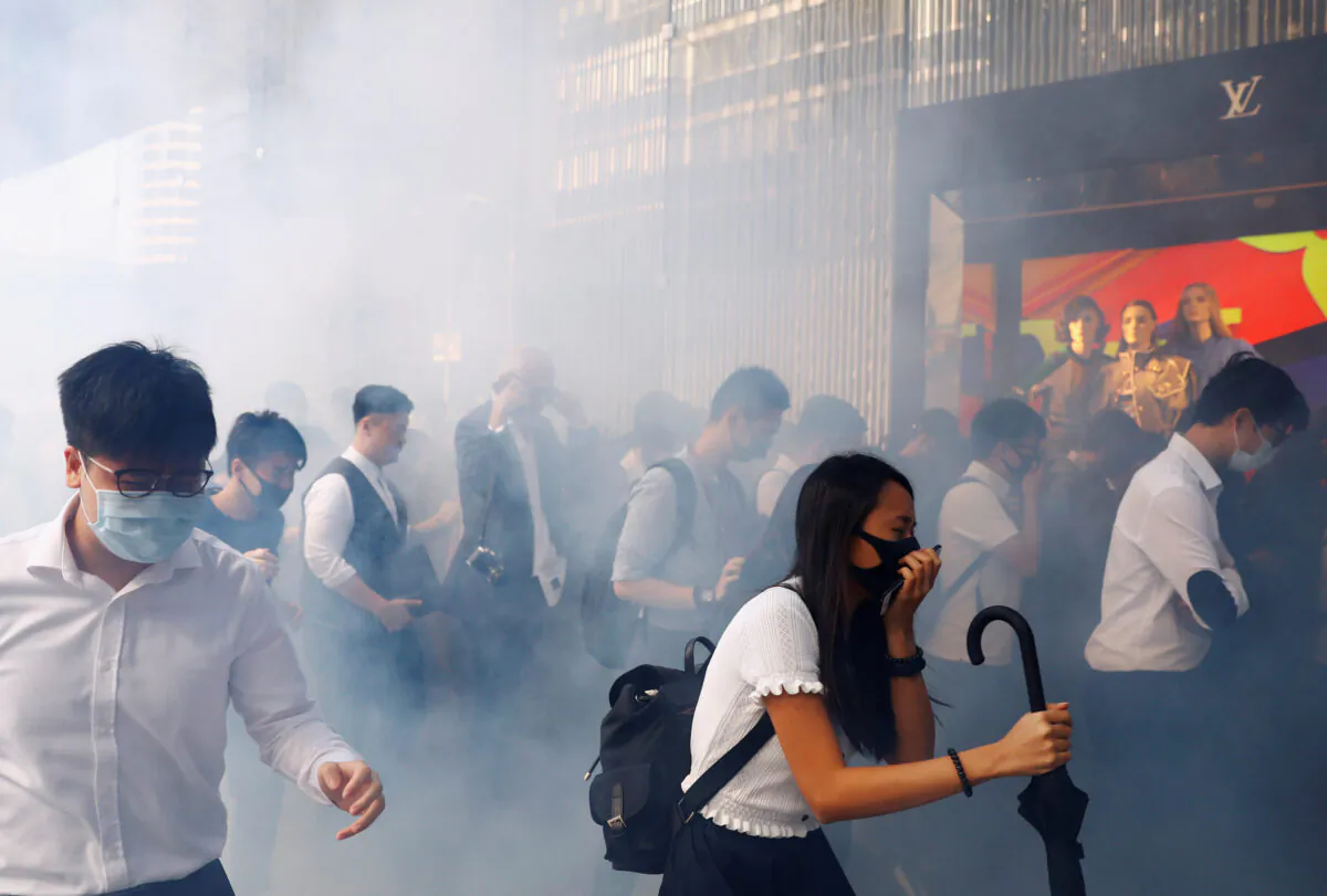 Office workers react after police fired tear gas, in Central, Hong Kong, China on Nov. 11, 2019. (Thomas Peter/Reuters)