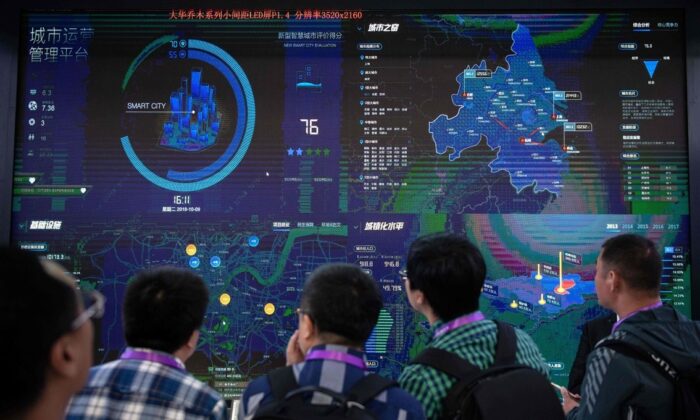 Visitors look at an AI (Artificial Inteligence) security software program on a screen at the 14th China International Exhibition on Public Safety and Security at the China International Exhibition Center in Beijing on Oct. 24, 2018. (NICOLAS ASFOURI/AFP via Getty Images)