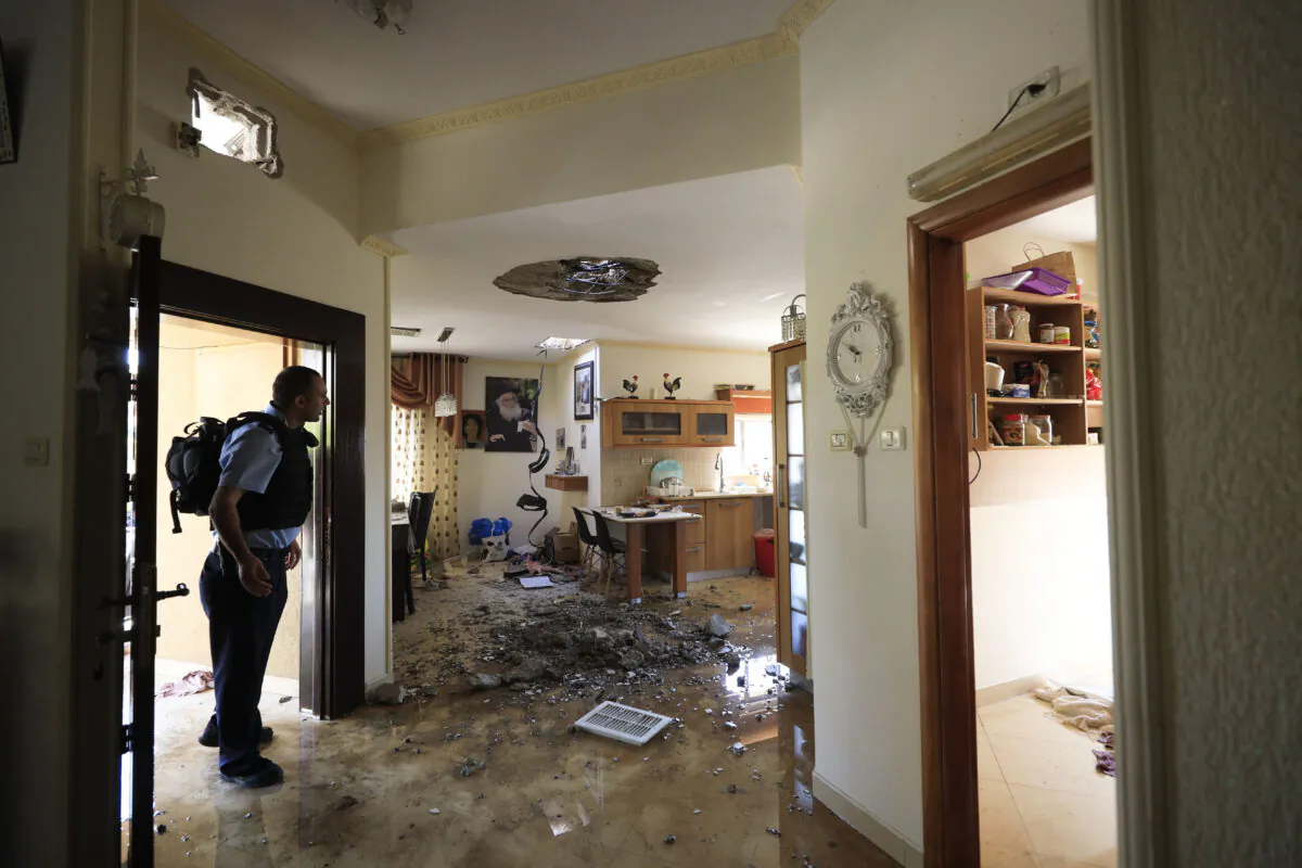 A policeman checks the damage to a house hit by a rocket in Netivot, Israel, after it was hit by a rocket fired from Gaza Strip, Tuesday, Nov. 12m 2019. (Tsafrir Abayov/AP)