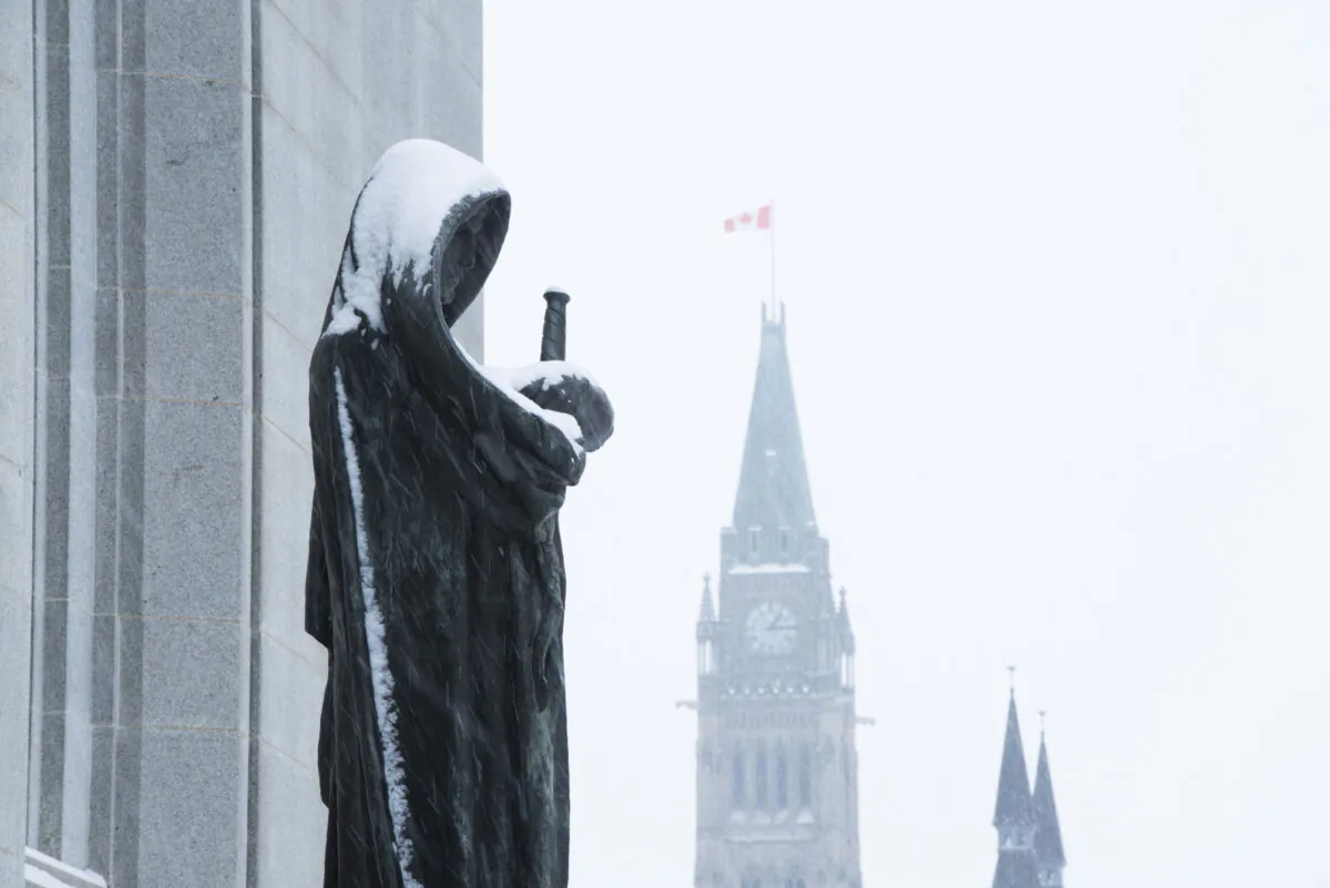 The Peace Tower of Parliament Hill is seen past the Statue of Justice at the Supreme Court of Canada in Ottawa on Nov. 14, 2019. (The Canadian Press/Sean Kilpatrick)