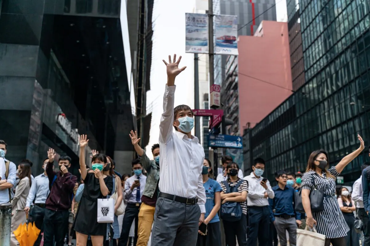 Pro-democracy supporters make gestures as they occupy a street in Central district in Hong Kong on November 14, 2019. (Anthony Kwan/Getty Images)