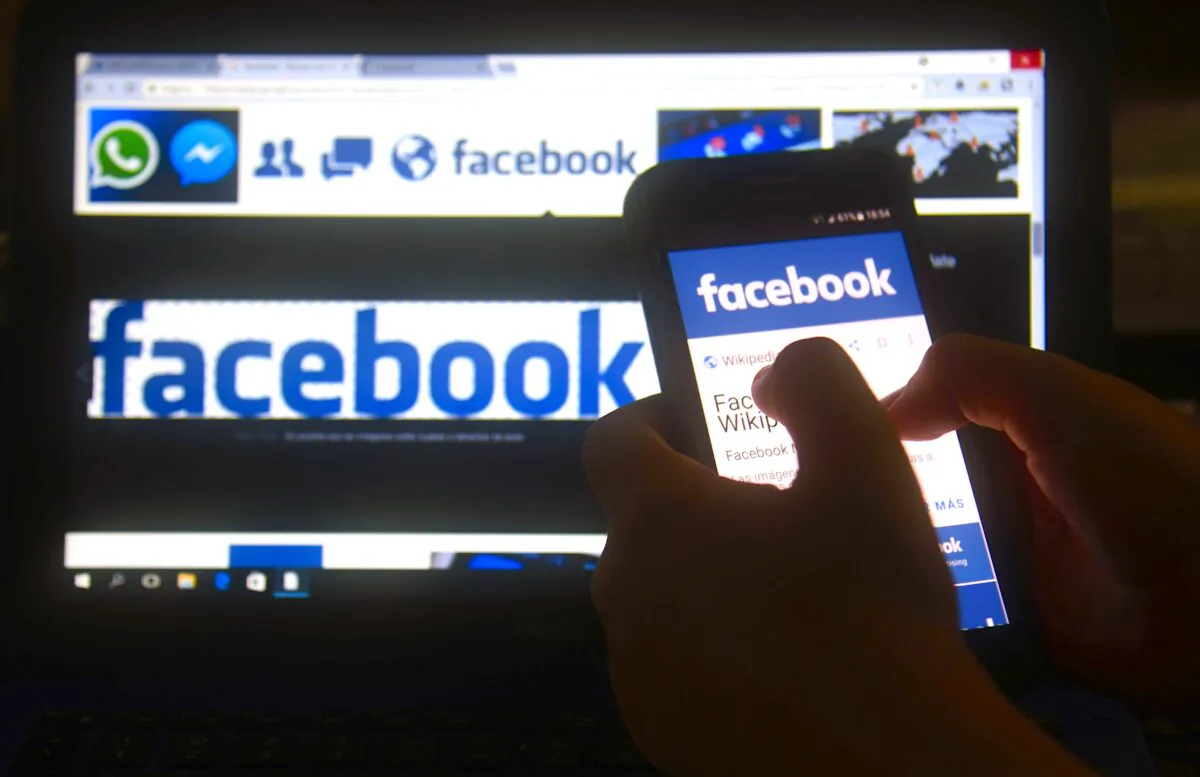 A cellphone and a computer screen display the logo of the social networking site Facebook in a file photograph. (Norberto Duarte/AFP via Getty Images)