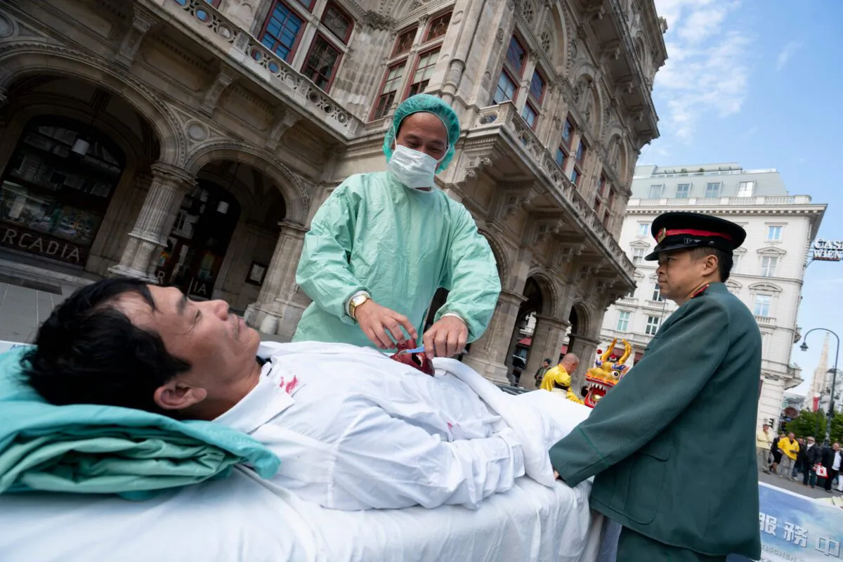 Adherents of Falun Gong reenact the forced organ harvesting of prisoners of conscience by the Chinese regime at a protest in Vienna on Oct. 1, 2018. (Joe Klamar/AFP via Getty Images)