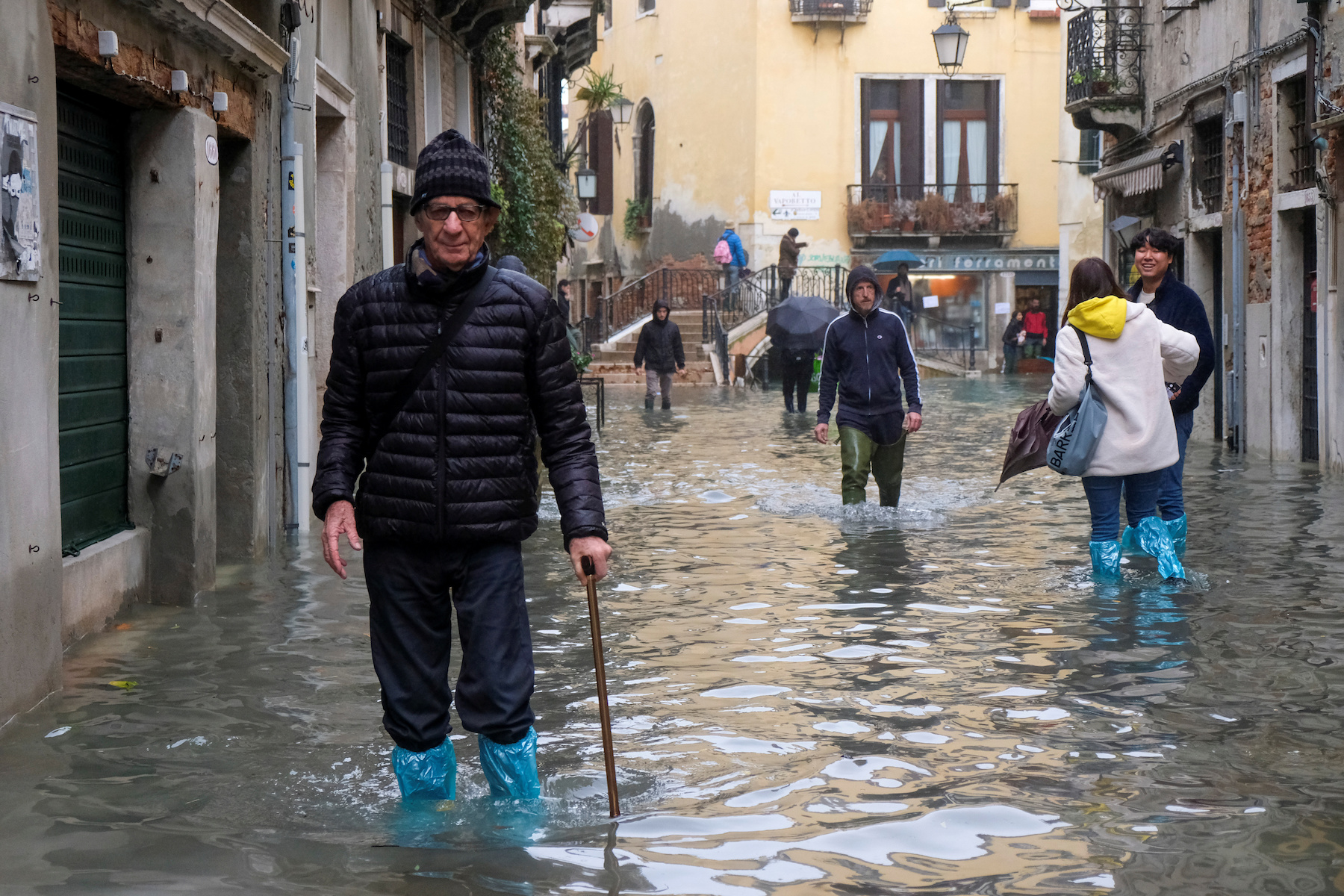 People walk outside during exceptionally high water levels in Venice