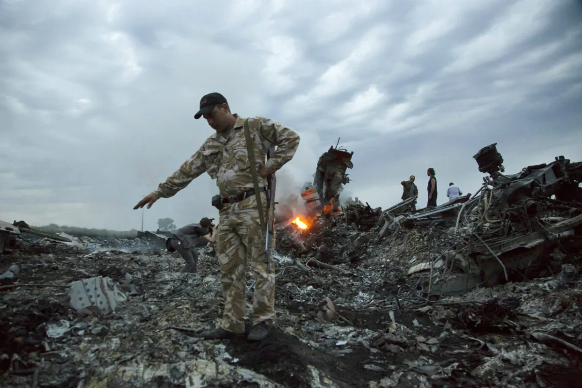 People walk amongst the debris at the crash site of Malaysia Airlines Flight 17 (MH17) passenger plane near the village of Grabovo, Ukraine, on July 17, 2014. (Dmitry Lovetsky/ AP Photo)