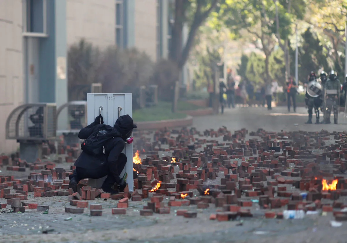 A protester hides behind a shield during clashes with police outside the Hong Kong Polytechnic University (PolyU) in Hong Kong, on November 17, 2019. (REUTERS/Adnan Abidi)