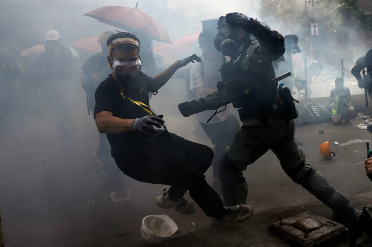 A protester is detained by riot police while attempting to leave the campus of Hong Kong Polytechnic University (PolyU) during clashes with police in Hong Kong, China on Nov. 18, 2019. (Thomas Peter/Reuters)