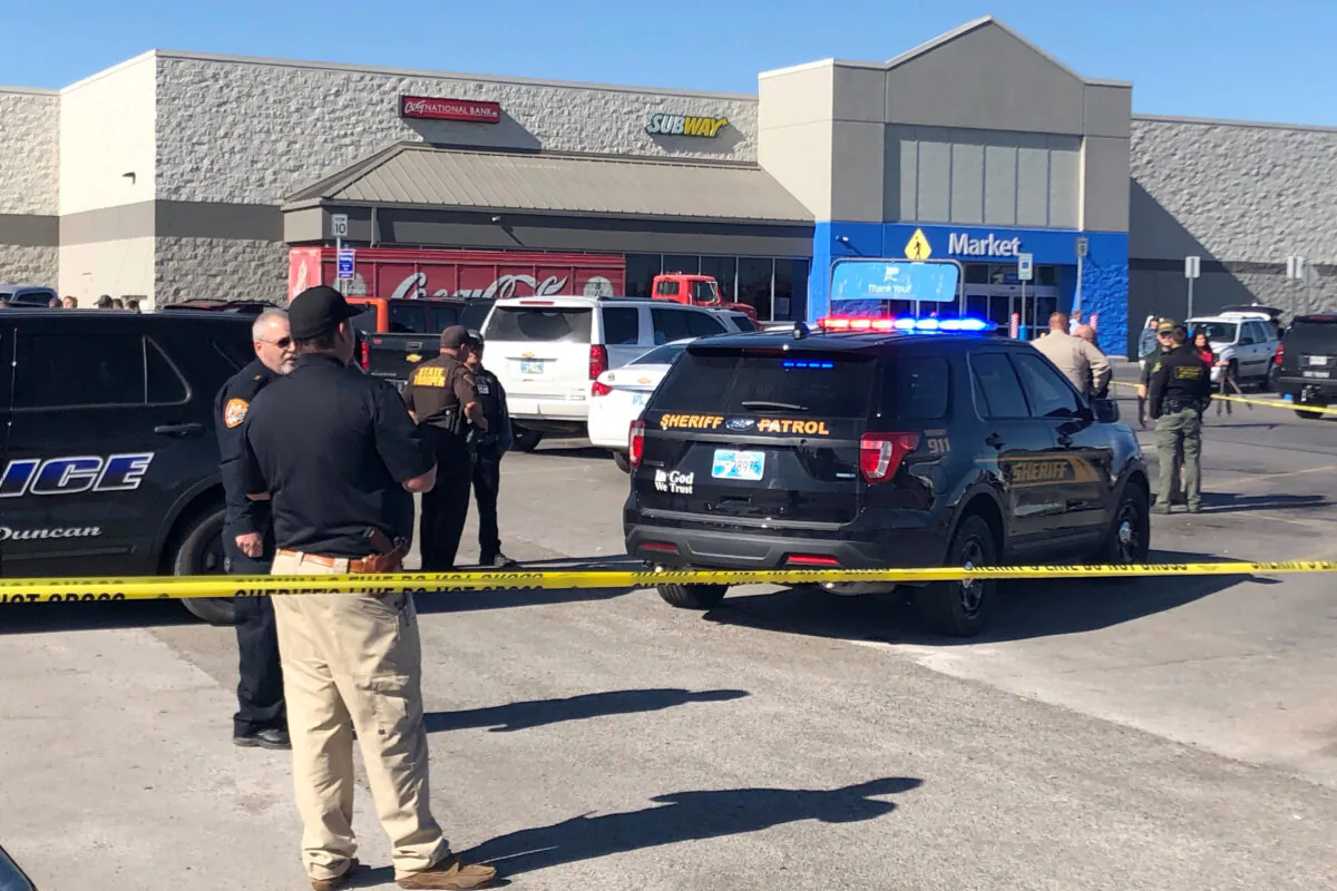 Law enforcement work the scene where two men and a woman were fatally shot outside a Walmart store in Duncan, Okla., on Nov. 18, 2019. (Sean Murphy/AP Photo)