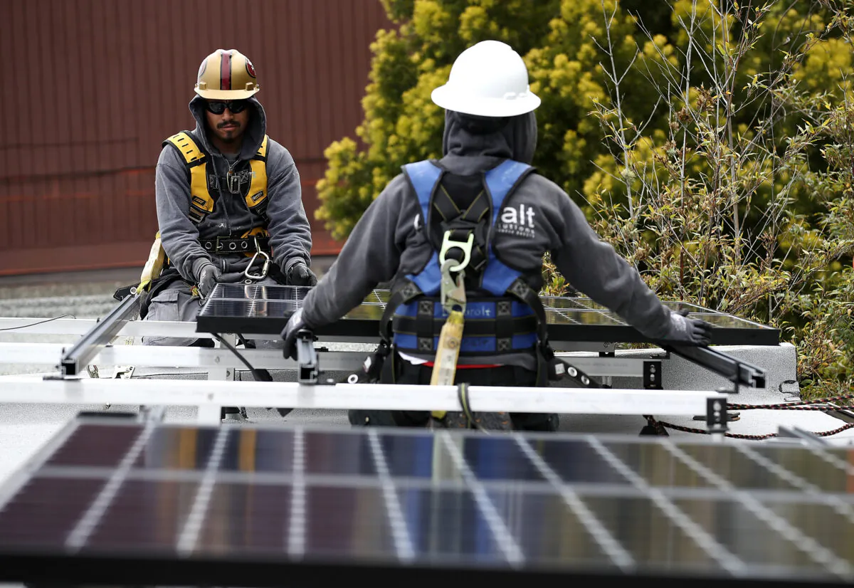 Workers install solar panels on the roof of a home in San Francisco, Calif., on May 9, 2018. (Justin Sullivan/Getty Images)