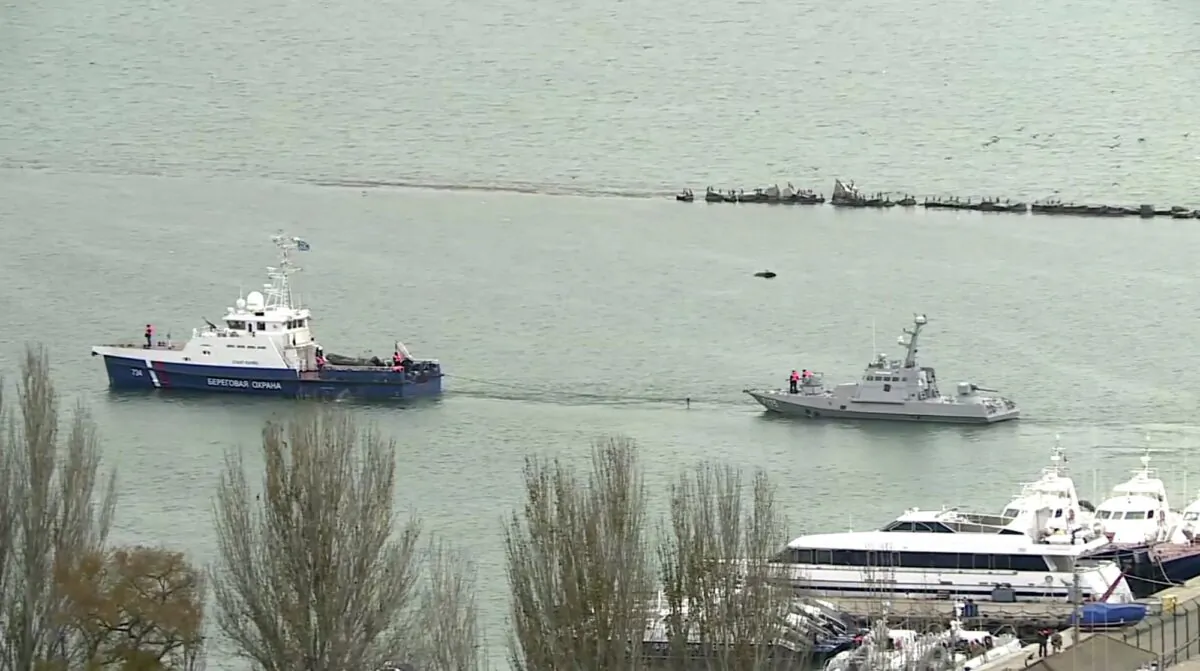 This video grab provided by the Krym 24 tv station via AP Television shows a seized Ukrainian ship, right, being towed by a Russian coast guard boat out of the port in Kerch, Crimea on Nov. 17, 2019. (Krym 24 tv station via AP Television)