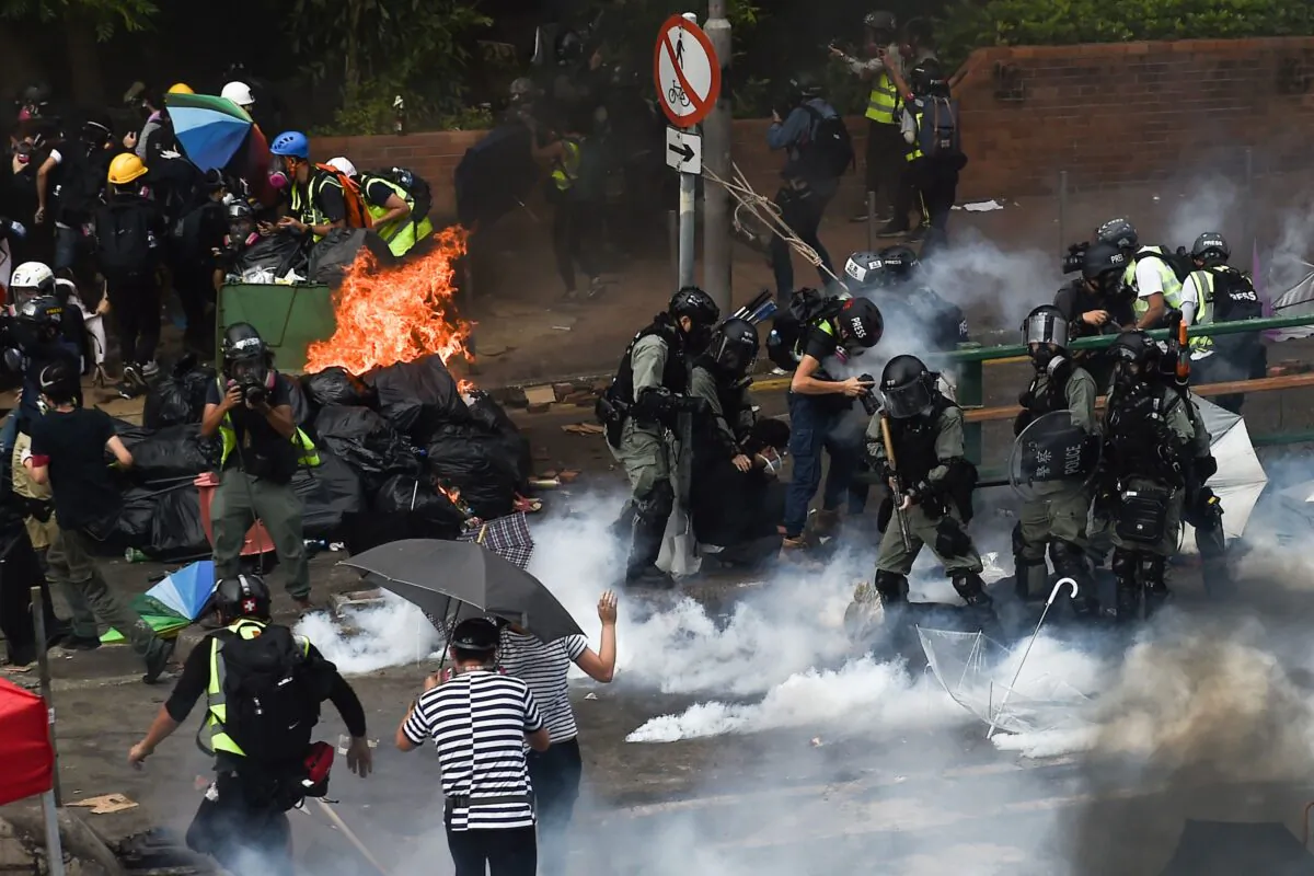 Riot police (R) make arrests as protesters (L) attempt to find safe passage out of the Hong Kong Polytechnic University campus in Hung Hom district of Hong Kong on Nov. 18, 2019. (Ye Aung Thu/AFP via Getty Images)