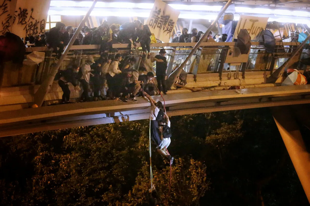 Pro-democracy protesters trapped inside Hong Kong Polytechnic University abseil onto a highway and escape before being forced to surrender during a police siege of the campus in Hong Kong, China on Nov. 18, 2019. (HK01/Handout via Reuters)