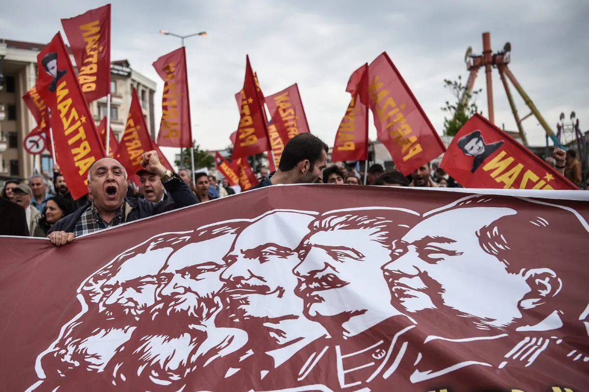 People hold a banner picturing Communist figures including (L–R) Karl Marx, Friedrich Engels, Vladimir Lenin, Josph Stalin, and Mao Zedong, as they gather in Bakirkoy district as part of the May Day rally in Istanbul on May 1, 2017.  (AFP PHOTO / OZAN KOSE)        