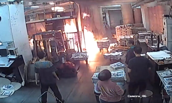 Staff at the print shop that prints the Hong Kong edition of The Epoch Times react to a fire started by four masked men on Nov. 19, 2019.