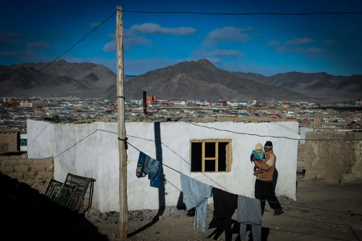 A man carrying a child in the center of Bayan-Ulgii, in Ulgii soum, Mongolia on March 4, 2014. - A Mongolian man was diagnosed with the bubonic plague on Nov. 16, 2019 after consuming a wild hare. (Byambasuren Byamba-Ochir/AFP via Getty Images)