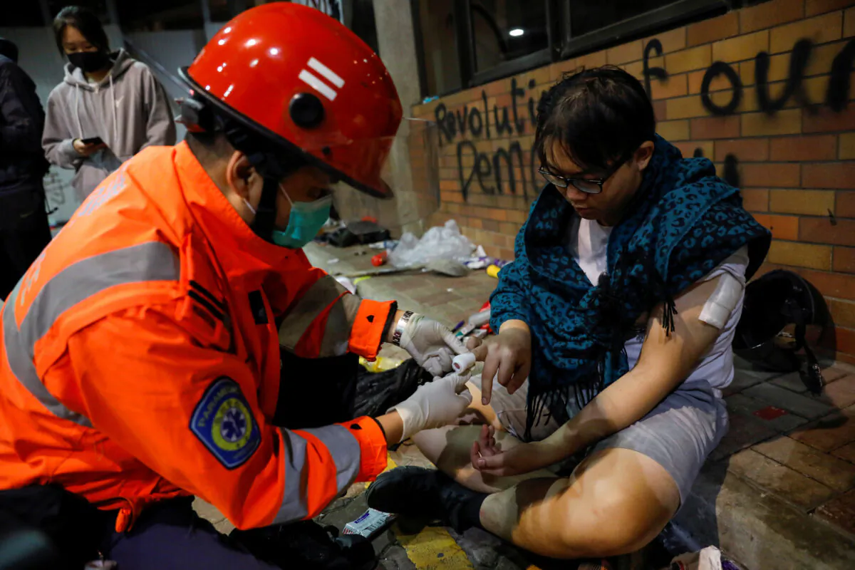 A protester receives medical attention inside the Hong Kong Polytechnic University campus during protests in Hong Kong, China on Nov. 19, 2019. (Adnan Abidi/Reuters)