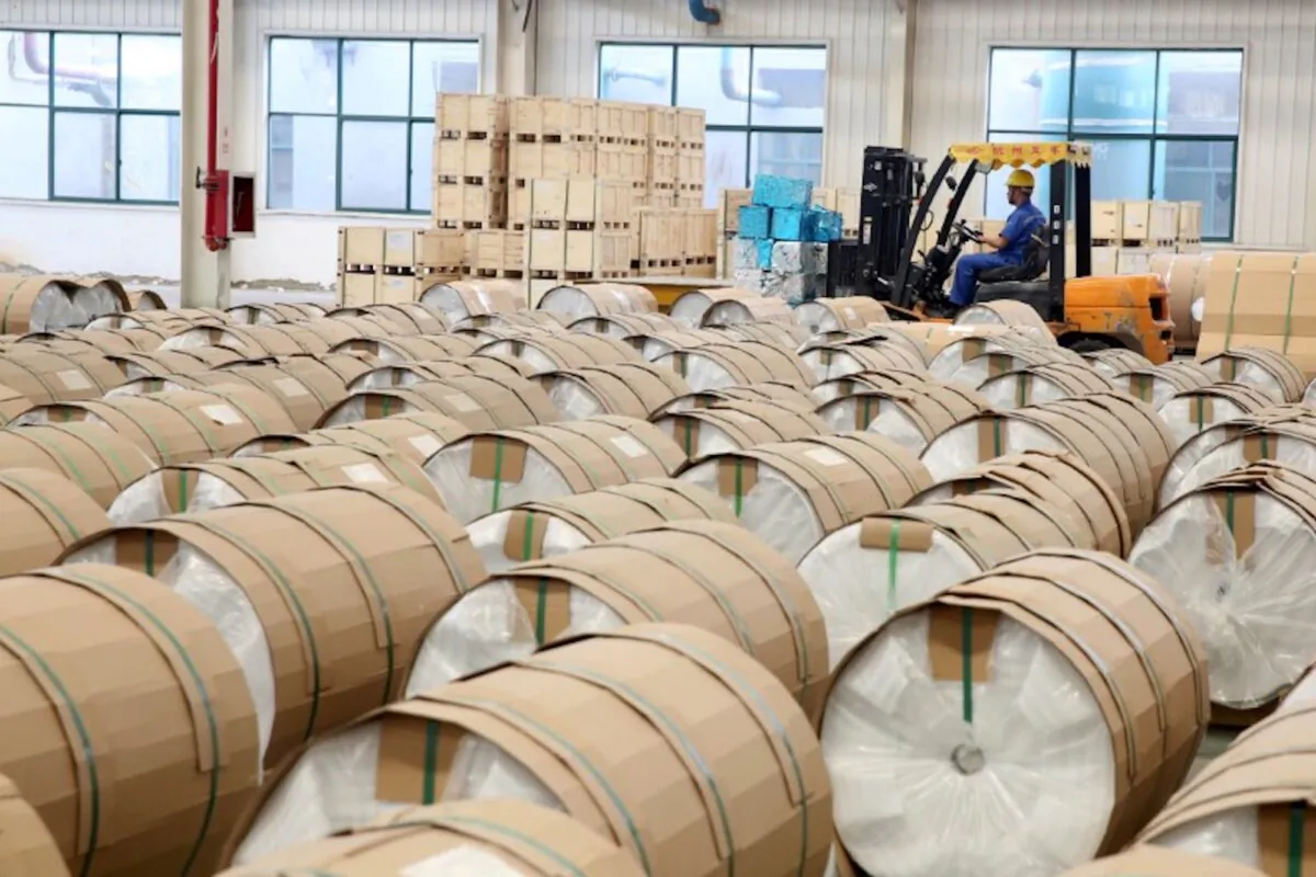 A man drives a forklift past rolls of aluminum coil for export, at a workshop of a company manufacturing aluminum products in Huaibei, Anhui Province, China on July 22, 2018. (Reuters)