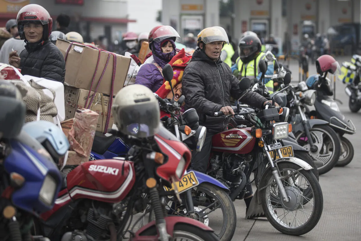 Chinese migrant workers rest at gas stations after riding motorcycles in Zhaoqing, Guangdong Province, China on Jan. 25, 2019. They are going back home together ahead of the Chinese New Year. (Wang He/Getty Images)