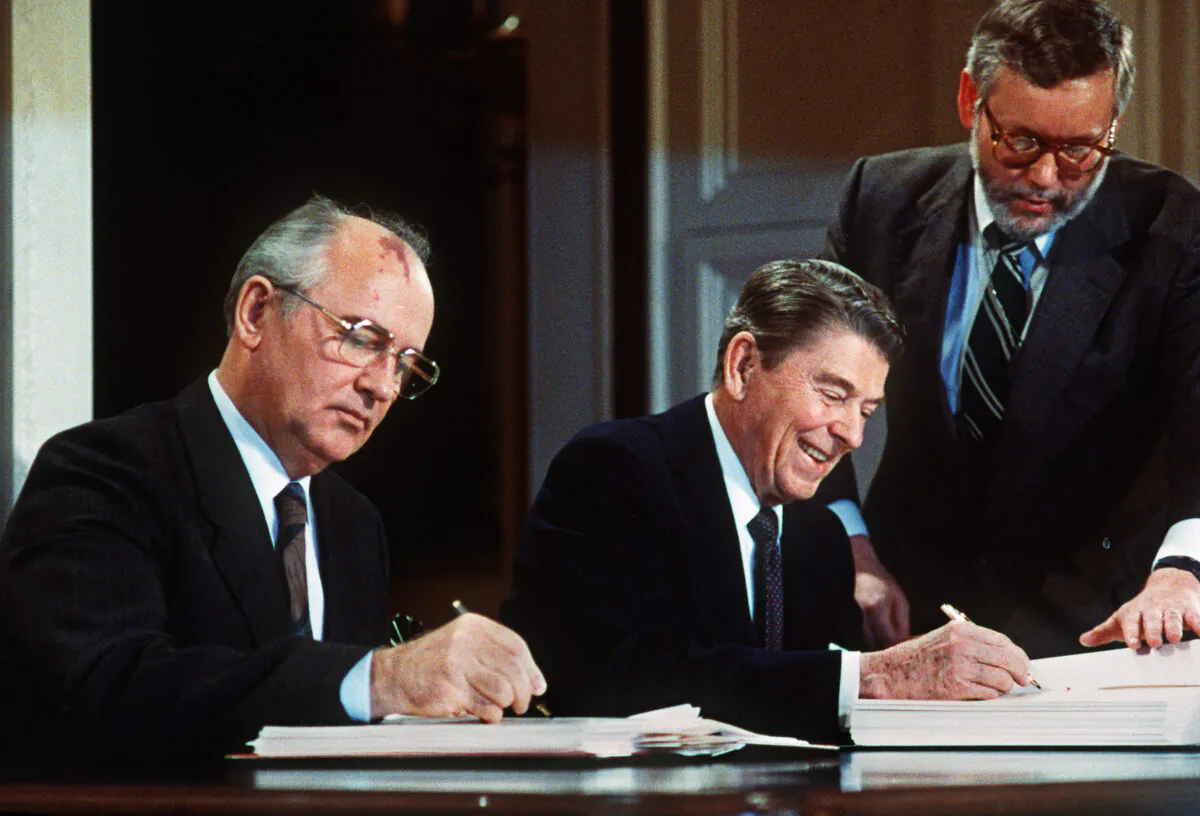 Soviet leader Mikhail Gorbachev (L) and US President Ronald Reagan sign at the Washington summit a treaty eliminating US and Soviet intermediate-range and shorter-range nuke missiles, on Dec. 8, 1987. (-/AFP via Getty Images)