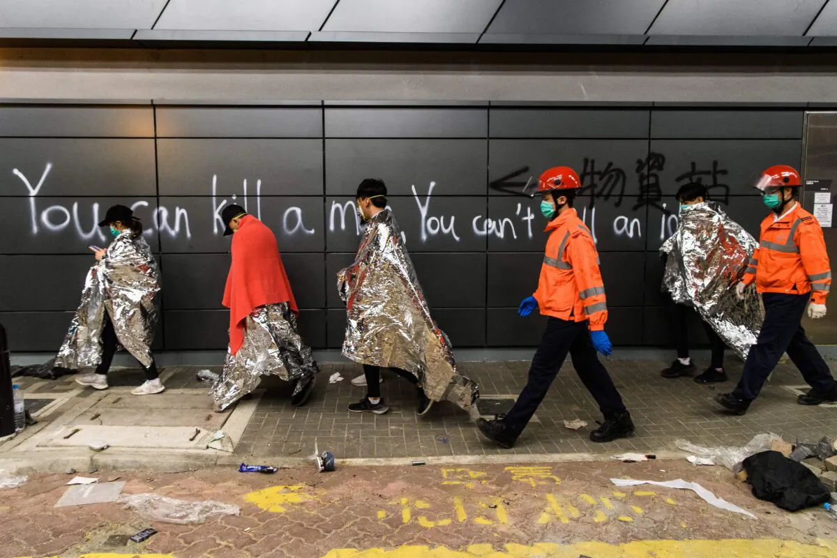 Protesters are taken by paramedics to ambulances from the campus of the Hong Kong Polytechnic University (PolyU) after being barricaded inside for days, in the Hung Hom district of Hong Kong on Nov. 20, 2019. (Anthony Wallace/AFP via Getty Images)