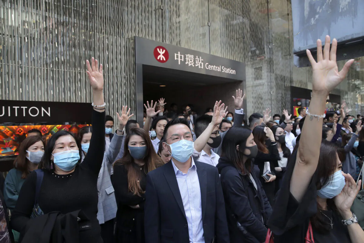 Protesters hold up their hands to symbolize pro-democracy demonstrators' five demands during a demonstration in the financial district in Hong Kong, Wednesday, Nov. 20, 2019. (AP Photo/Kin Cheung)