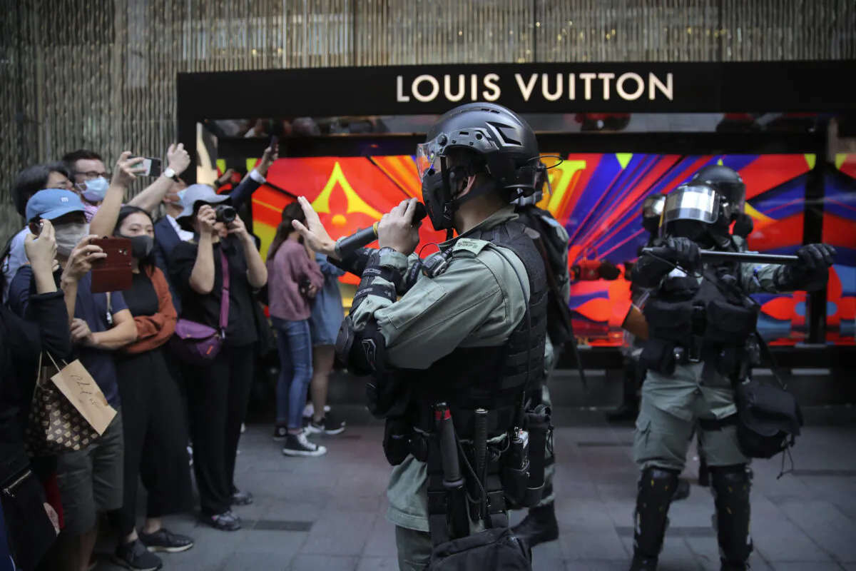 Riot police speak to protesters during a demonstration in the financial district in Hong Kong, China on Nov. 20, 2019. Hong Kong schools reopened on Wednesday after a six-day shutdown but students and commuters faced transit disruptions as the last protesters remained holed up on a university campus. (Kin Cheung/AP)