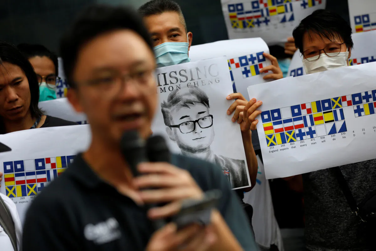 A demonstrator holds a poster of Simon Cheng, a staff member at the consulate who went missing on Aug. 9 after visiting the neighboring mainland city of Shenzhen, as he and others shout slogans during a protest outside the British Consulate-general office in Hong Kong, China, on Aug. 21, 2019. (Willy Kurniawan/Reuters)