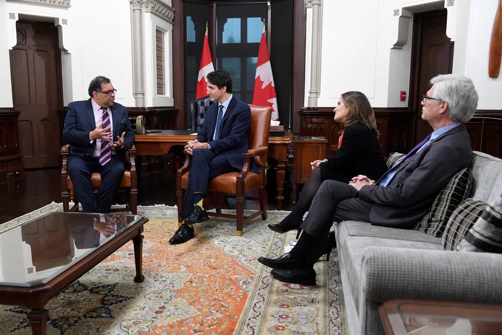 Deputy Prime Minister Chrystia Freeland and Jim Carr look on as Prime Minister Justin Trudeau speaks with Calgary mayor Naheed Nenshi in his office on Parliament Hill in Ottawa on Nov. 21, 2019. (The Canadian Press/Adrian Wyld)