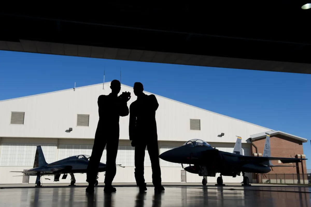 Pilots with the U.S. Air Force stand inside a hangar alongside a F-15 fighter jet and a T-38 Talon trainer jet during the inaugural Trilateral Exercise between the US Air Force, United Kingdom's Royal Air Force and the French Air Force at Joint Base Langley-Eustis in Hampton, Va., on Dec. 15, 2015. (Saul Loeb/AFP via Getty Images)