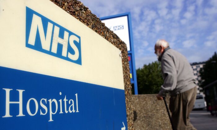 An elderly gentleman walks past a hospital sign in London on Sept 26, 2007. (Cate Gillon/Getty Images)