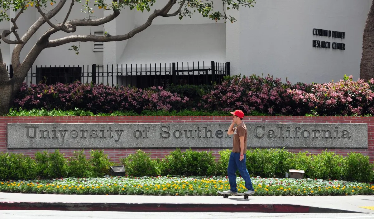 A student rides his skateboard past an entrance to the University of Southern California campus in Los Angeles on April 11, 2012. (Frederic J. Brown/AFP via Getty Images)
