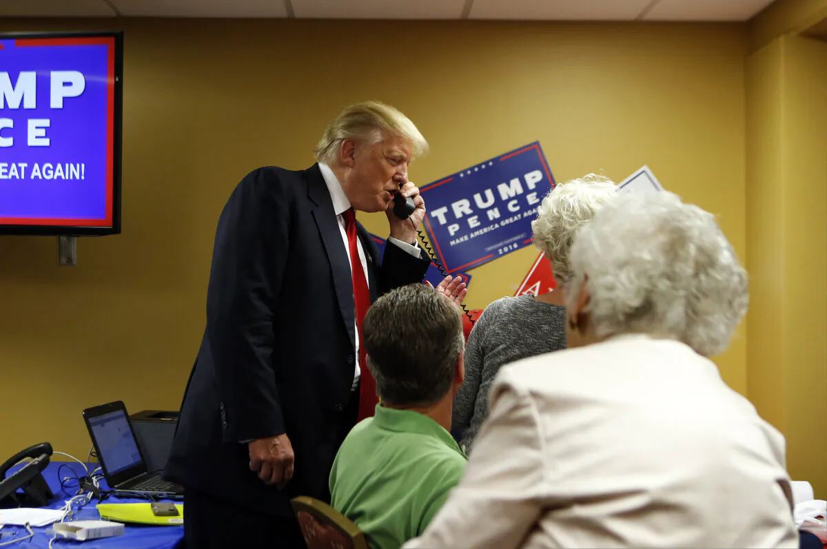 Republican presidential candidate Donald Trump speaks to a caller on the other end of the phone line as volunteers man a phone bank prior to a rally at U.S. Cellular Center in Asheville, North Carolina on Sept. 12, 2016. (Brian Blanco/Getty Images)