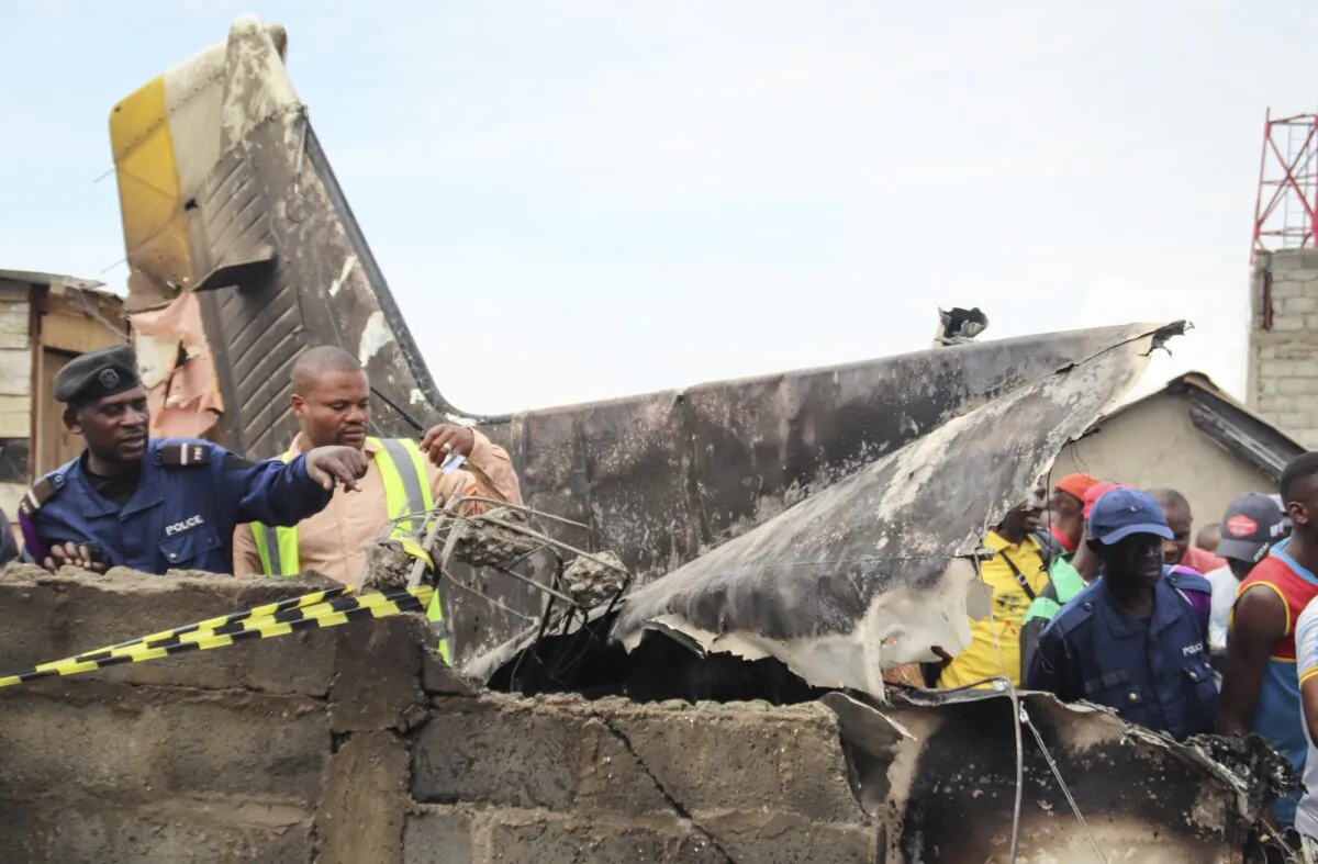 Rescuers and onlookers gather amidst the debris of an aircraft operated by private carrier Busy Bee which crashed in Goma, Congo on Nov. 24, 2019. (Justin Kabumba/AP Photo)