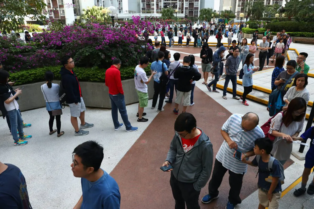 Voters queue to vote at a polling station during district council local elections on Hong Kong Island, China on Nov. 24, 2019. (Athit Perawongmetha/Reuters)