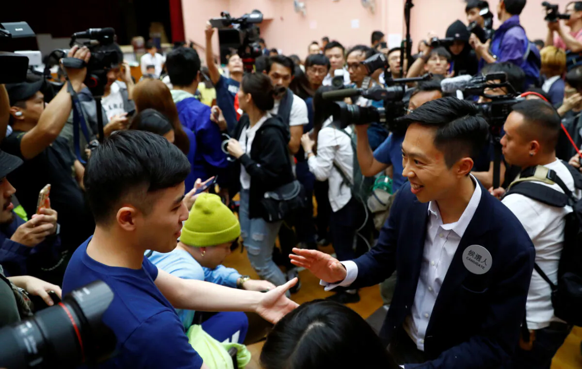 Local candidate Kelvin Lam celebrates with supporters after it was announced he won the local council elections in his district, at a polling station in the South Horizons West district in Hong Kong, on Nov. 25, 2019. (Thomas Peter/Reuters)
