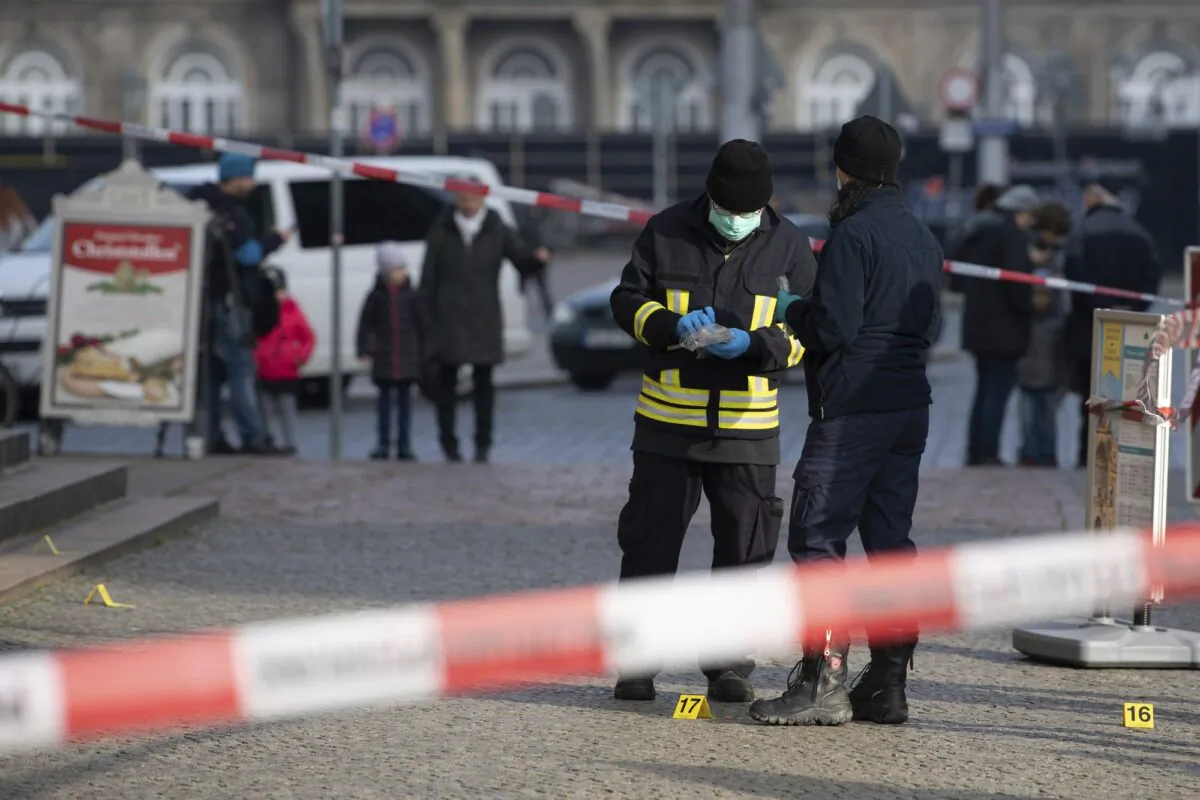 Police officers stand behind a caution tape at the Schinkelwache building in Dresden on Nov. 25, 2019. (Sebastian Kahnert/dpa via AP)