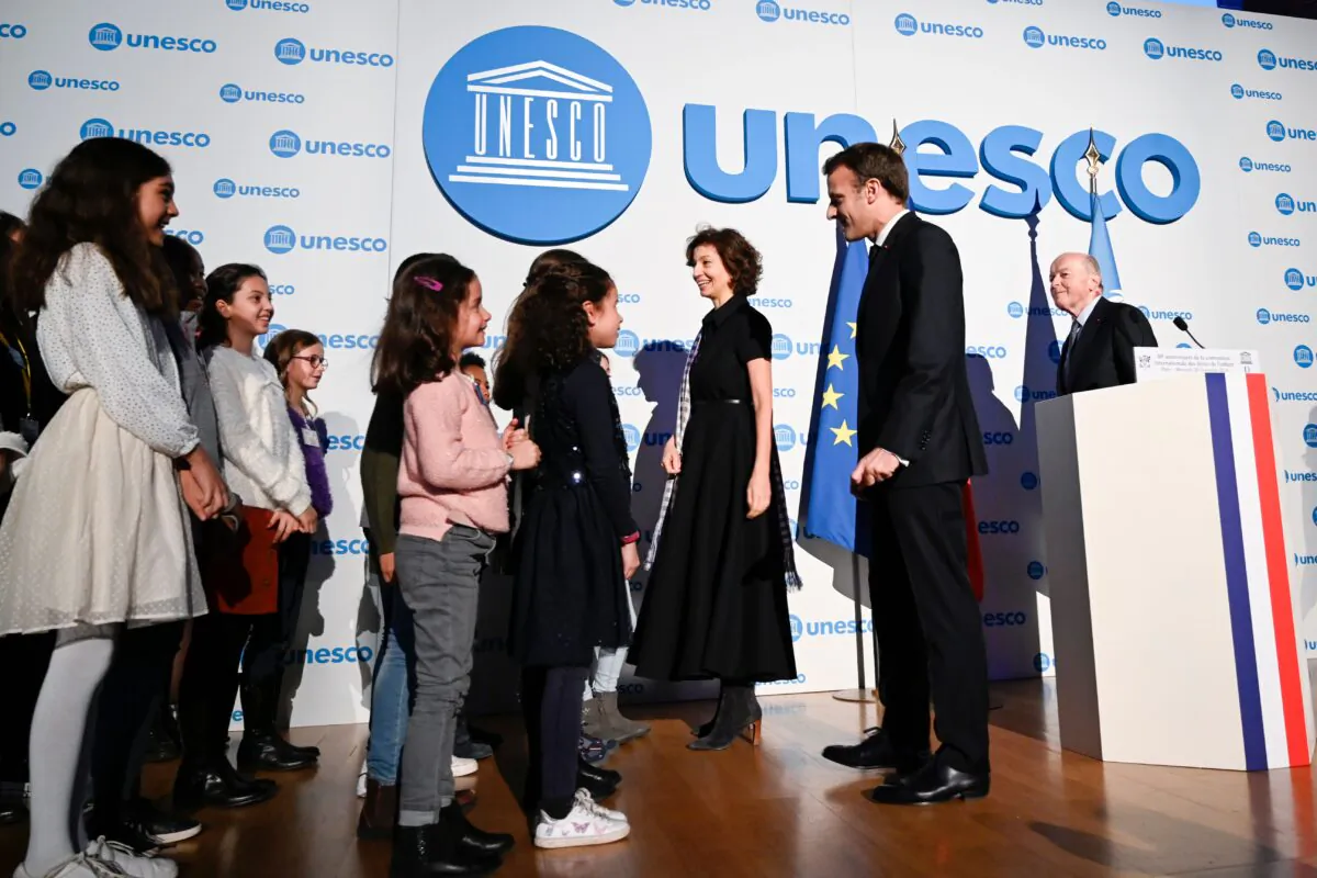 UNESCO Director-General Audrey Azoulay (3rd R), French President Emmanuel Macron (2nd R) and French Ombudsman Jacques Toubon (R) welcome children during the 30th anniversary of the Convention on the Rights of the Child at the UNESCO in Paris on Nov. 20, 2019.
(Photo by Eric Feferberg / POOL / AFP)