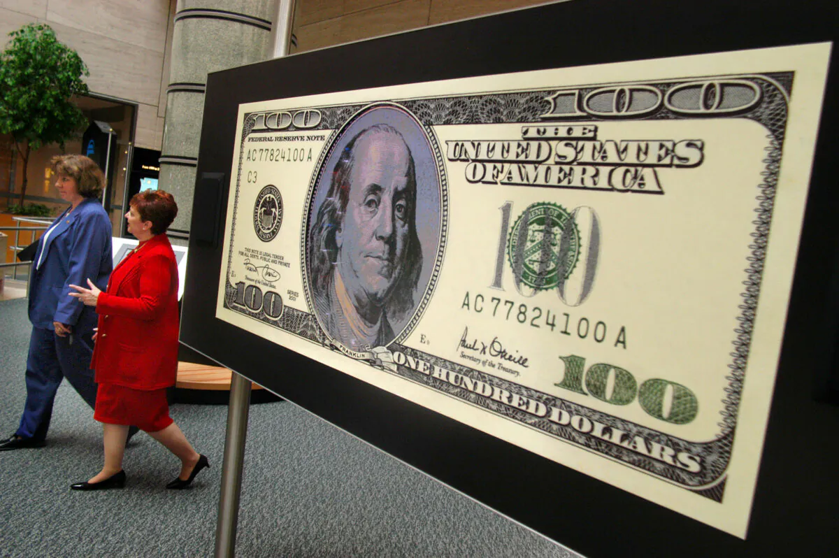 Two unidentified women walk past a video $100 bill during a tour of the "Money in Motion" exhibit at the Philadelphia Federal Reserve Bank in Philadelphia, Penn., on July 2, 2003. (William Thomas Cain/Getty Images)