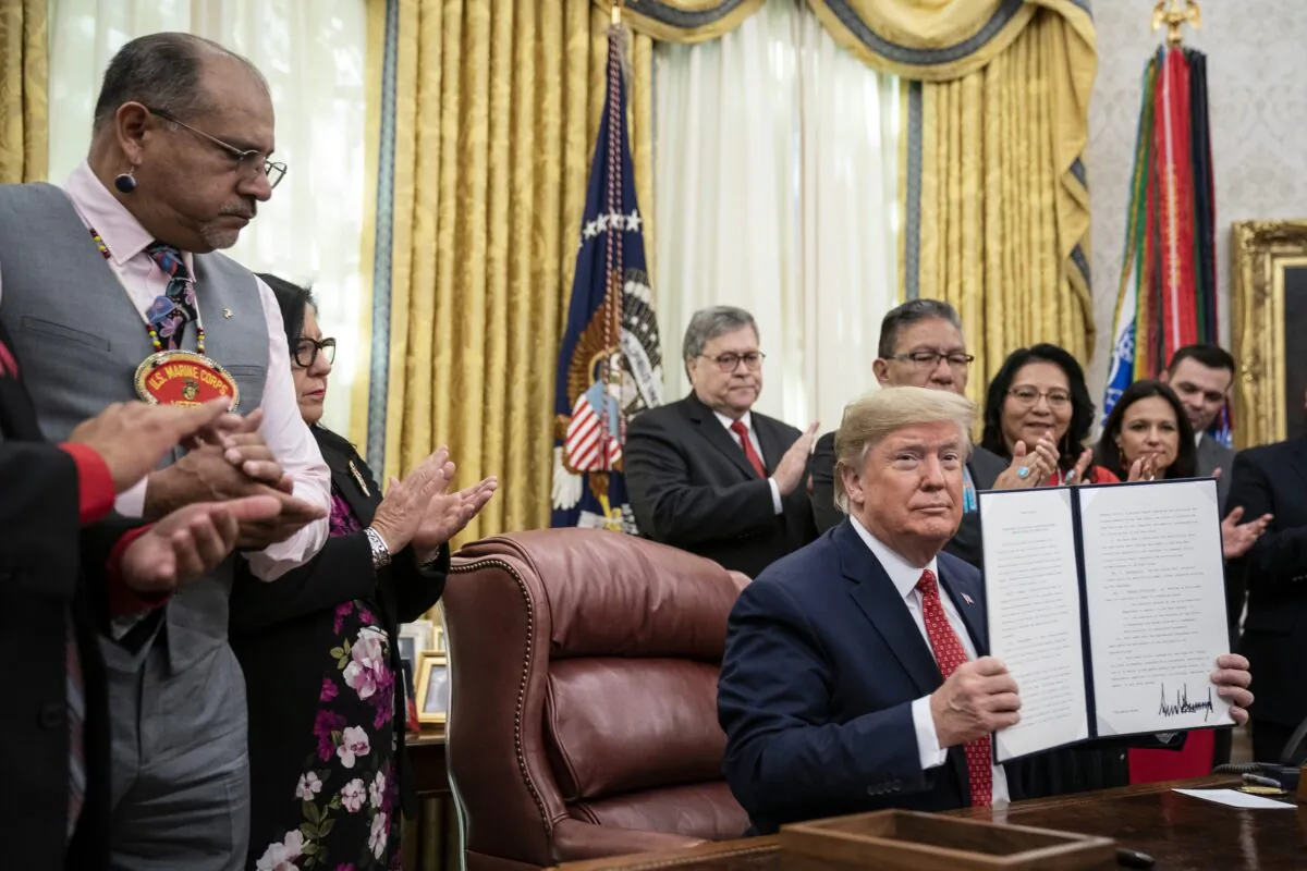 President Donald Trump signs an executive order establishing the Task Force on Missing and Murdered American Indians and Alaska Natives, in the Oval Office of the White House in Washington on Nov. 26, 2019. (Drew Angerer/Getty Images)