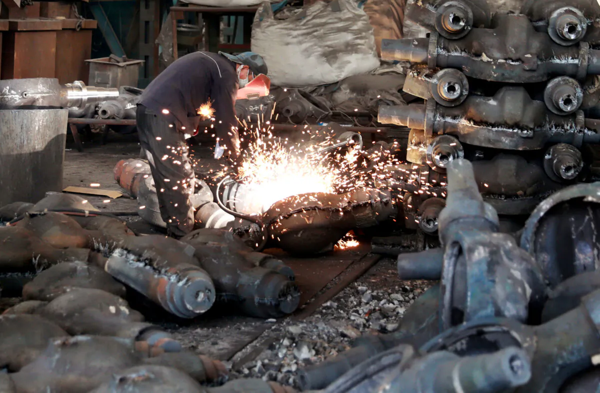 A worker welds automobile parts at a workshop manufacturing automobile accessories in Huaibei, Anhui Province, China on June 28, 2019. (Reuters)