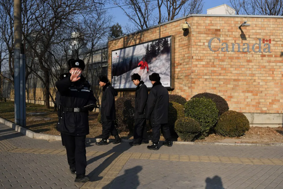 A Chinese policeman tries to block the photographer at the Canadian Embassy in Beijing on Dec. 14, 2018. (Greg Baker/AFP via Getty Images)