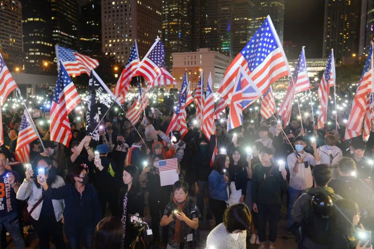 Protestors wave U.S. flags and hold up their lit-up mobile phones as they attend a gathering at the Edinburgh place in Hong Kong on Nov. 28, 2019. (Sung Pi Lung/The Epoch Times)