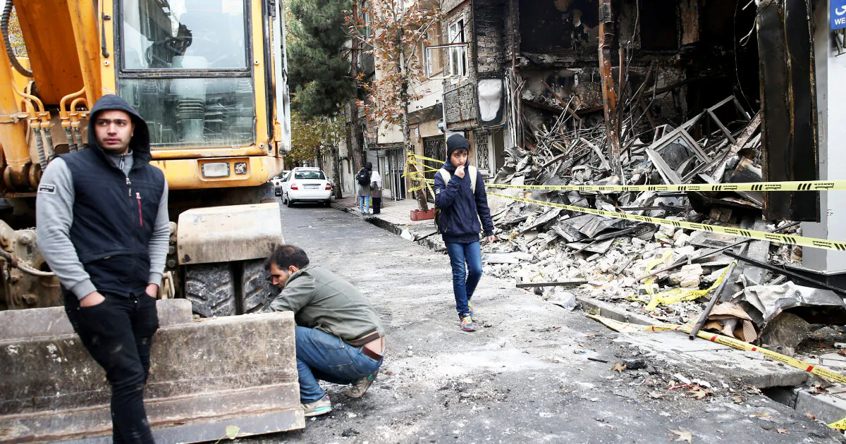 People walk near a burnt bank, after protests against increased fuel prices, in Tehran, Iran Nov. 20, 2019. (Nazanin Tabatabaee/WANA (West Asia News Agency) via Reuters)
