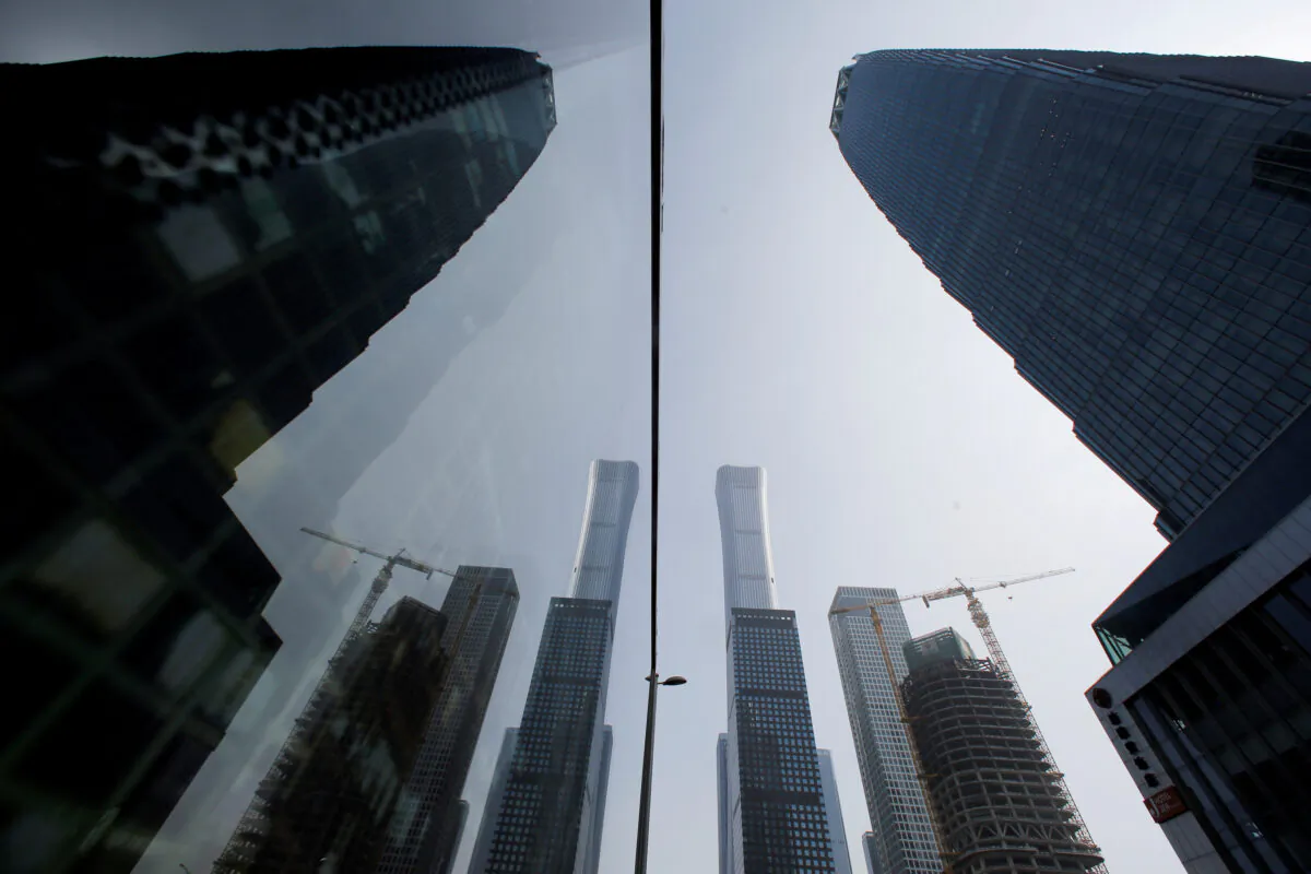 Skyscrapers in the Central Business District (CBD) are reflected in a window in Beijing, China on March 4, 2019. (Thomas Peter/Reuters)