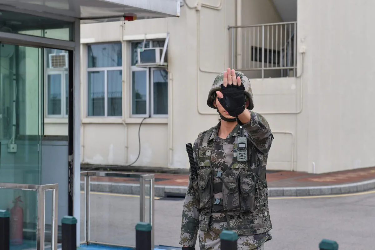 A Chinese soldier gestures at an entrance to the headquarters of the People's Liberation Army Hong Kong Garrison in the Admiralty district in Hong Kong on October 7, 2019. (NICOLAS ASFOURI/AFP via Getty Images)