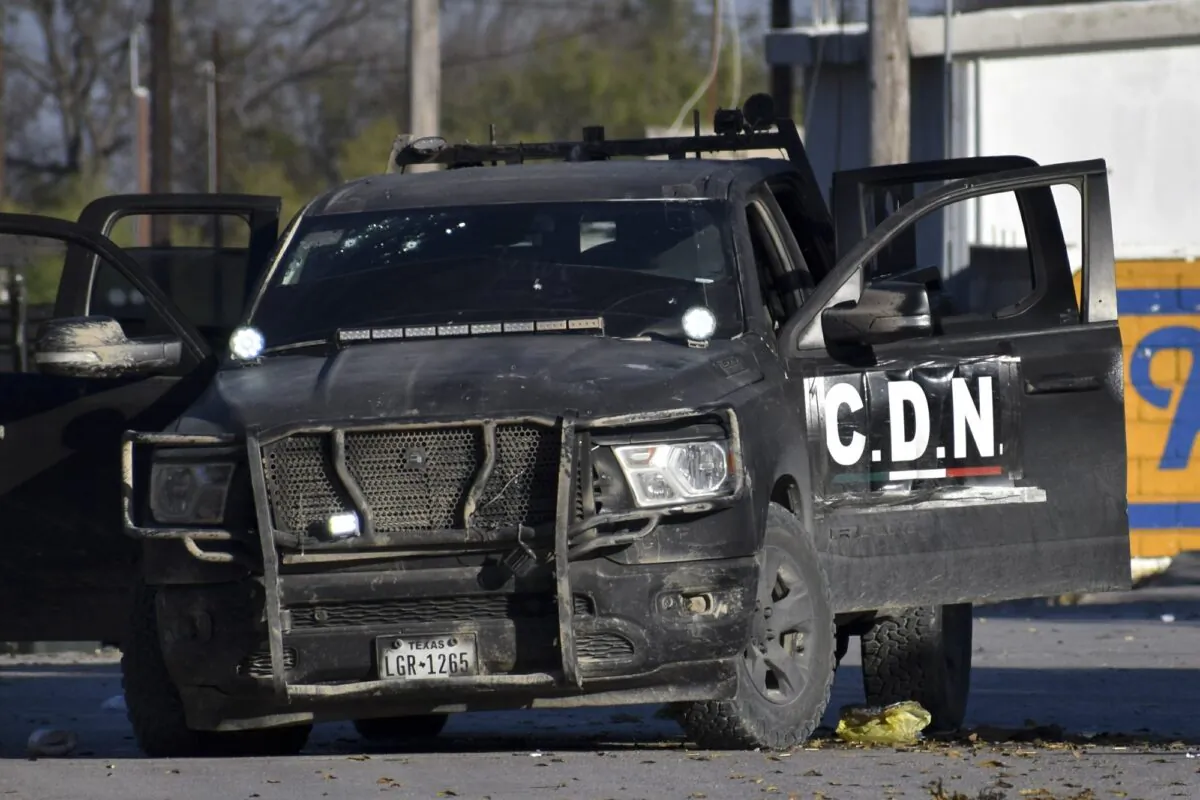 A damaged pickup marked with the initials C.D.N., that in Spanish stand for Cartel of the Northeast, is on the streets after a gun battle between Mexican security forces and suspected cartel gunmen, in Villa Union, Mexico, on Nov. 30, 2019. (Gerardo Sanchez/AP Photo)
