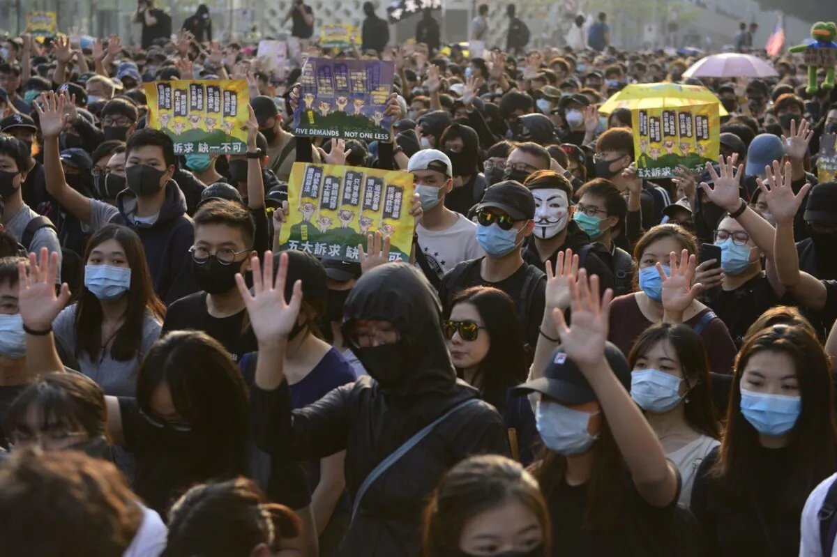 Protesters raise their hands to signal their five demands in a march in Tsim Sha Tsui, Hong Kong, on Dec. 1, 2019. (Gordan Yu/The Epoch Times)