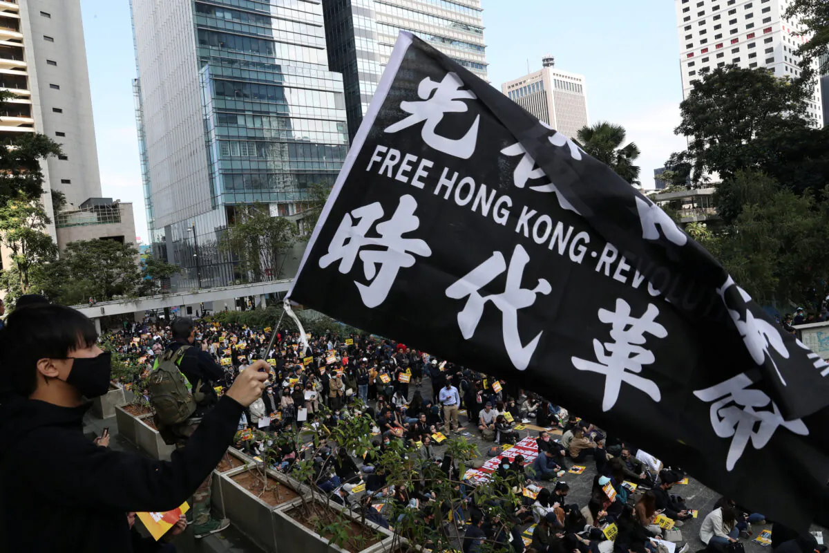 A pro-democracy demonstrator holds a flag as people gather for a lunchtime protest at Chater Garden in Hong Kong, China on Dec. 2, 2019. (Leah Millis/Reuters)